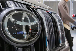 A visitor walks by a Toyota car displayed at a Toyota Motor Corp. showroom.