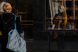 Two women wait in line at a bakery in Antwerp, Belgium, Nov. 4, 2020.