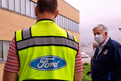 Missouri Gov. Mike Parson talks to a Ford representative outside Ford's Kansas City Assembly Plant.