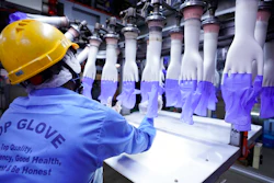 A worker inspects disposable gloves at the Top Glove factory in Shah Alam on the outskirts of Kuala Lumpur, Malaysia.