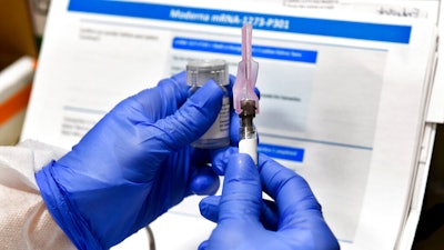 Nurse Kathe Olmstead prepares a shot that is part of a possible COVID-19 vaccine.