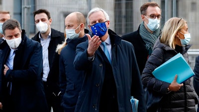 In this file photo dated Thursday, Nov. 12, 2020, European Commission's Head of Task Force for Relations with the United Kingdom Michel Barnier, centre, leaves the Conference Centre in London with unidentified members of his team. The Brexit trade negotiations have been suspended Thursday Nov. 19, 2020, at a crucial stage because an EU negotiator has tested positive for the coronavirus and EU chief negotiator Michel Barnier said that “we have decided to suspend the negotiations at our level for a short period.”