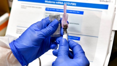 In this July 27, 2020, file photo, nurse Kathe Olmstead prepares a shot that is part of a possible COVID-19 vaccine, developed by the National Institutes of Health and Moderna Inc., in Binghamton, N.Y. Moderna said Monday, Nov. 16, 2020, its COVID-19 shot provides strong protection against the coronavirus that's surging in the U.S. and around the world.