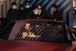 A woman exits a car on display during a promotion held in a popular shopping district in Beijing, Nov. 8, 2020.