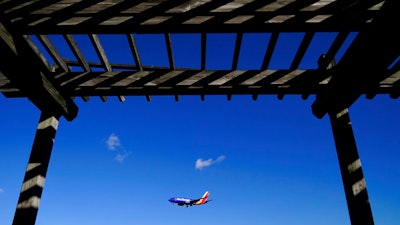 A shelter is seen at the Thomas Dixon Aircraft Observation Area as a Southwest Airlines flight from Jacksonville, Fla., makes its landing approach onto Baltimore-Washington International Thurgood Marshall Airport, Monday, Nov. 23, 2020, in Glen Burnie, Md. With coronavirus cases spiking in the U.S. and Europe, the financial outlook of the world's airlines is getting worse. The International Air Transport Association said Tuesday that around the world, airlines will lose more than $157 billion this year and next.