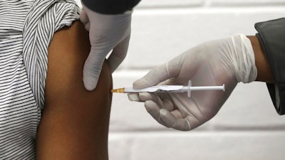 In this Wednesday, June 24, 2020 file photo, a volunteer receives an injection at the Chris Hani Baragwanath hospital in Soweto, Johannesburg, as part of Africa's first participation in a COVID-19 vaccine trial developed at the University of Oxford in Britain in conjunction with the pharmaceutical company AstraZeneca. On Friday, Oct. 23, 2020, AstraZeneca Inc. announced that the Food and Drug Administration is letting it resume testing of its COVID-19 vaccine candidate in the U.S.