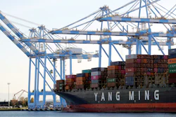 Cargo cranes take containers off a Yang Ming Marine Transport Corporation boat at the Port of Tacoma in Tacoma, Wash., Nov. 4, 2019.