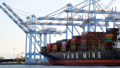 Cargo cranes take containers off a Yang Ming Marine Transport Corporation boat at the Port of Tacoma in Tacoma, Wash., Nov. 4, 2019.