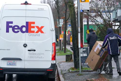 A driver with FedEx carries a package away from a van, Tuesday, Dec. 8, 2020, in Seattle.