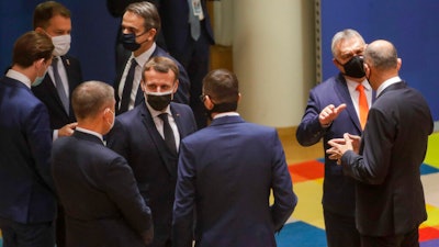 French President Emmanuel Macron, center, speaks with Czech Republic's Prime Minister Andrej Babis, third left, and Poland's Prime Minister Mateusz Morawiecki, center right, during a round table meeting at an EU summit at the European Council building in Brussels, Thursday, Dec. 10, 2020.