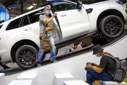 In this Sept. 26, 2020, file photo, a visitor wearing a face mask to protect against the coronavirus looks at an SUV vehicle on display at the Beijing International Automotive Exhibition, also known as Auto China, in Beijing. China’s sales of SUVs, minivans and sedans rose by double digits in November as the country recovered from the coronavirus pandemic but were below pre-virus levels for the year to date, an industry group reported Friday.