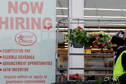 A man pushes carts as a hiring sign shows at a Jewel Osco grocery store in Deerfield, Ill., Thursday, April 23, 2020. Friday, Dec. 4, monthly U.S. jobs report will help answer a key question hanging over the economy: Just how much damage is being caused by the resurgent coronavirus, the resulting restrictions on businesses and the reluctance of consumers to shop, travel and dine out?