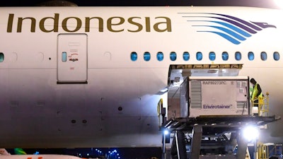 In this photo released by Indonesian Presidential Palace, workers unload a container containing experimental coronavirus vaccines made by Chinese company Sinovac from the cargo bay of a Garuda Indonesia plane at the Soekarno-Hatta International Airport in Tangerang, Indonesia, late Sunday, Dec. 6, 2020. Indonesia's government said more than a million doses of an experimental COVID-19 vaccine developed by China-based biopharmaceutical company Sinovac Biotech arrived in the country late Sunday and more are expected to arrive in early January.