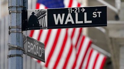 In this Nov. 23, 2020, photo, a street sign is displayed at the New York Stock Exchange in New York. S&P DJ Indices is removing 21 Chinese companies from its indexes, or groups of stocks and bonds used to track financial market movements, after Americans were barred from investing in them as part of a feud with Beijing over technology and security.