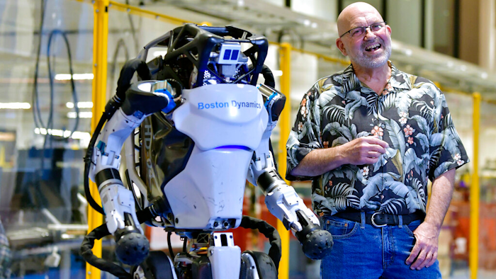 Marc Raibert, founder and chair of Boston Dynamics, stands beside one of the company's Atlas robots at its facilities in Waltham, Mass., Jan. 13, 2021.