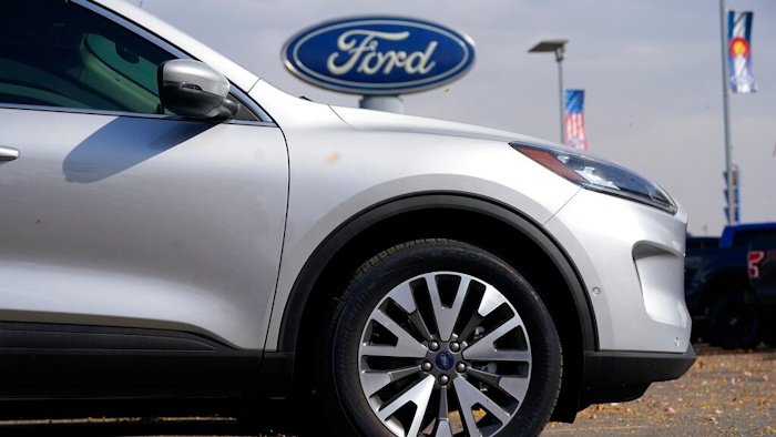 In this Sunday, Oct. 11, 2020 file photo, A row of 2020 Ford Escape sports-utility vehicles sits at a Ford dealership in Denver. A widening global shortage of semiconductors for auto parts is forcing major auto companies to halt or slow vehicle production just as they were recovering from pandemic-related factory shutdowns. Ford had scheduled down time next week at its Louisville, Kentucky, assembly plant, but moved it ahead to this week. The plant makes the Ford Escape and Lincoln Corsair small SUVs.