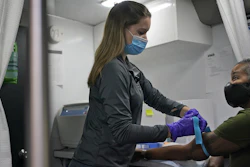 Nurse Brianne Stockman prepares to draw blood from study participant Lani Muller in a mobile medical unit, Queens, New York, Jan. 5, 2021.