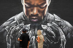 Pedestrians look up at a mural by artist Shane Grammer of late actor Chadwick Boseman's character T'Challa from the 2018 film 'Black Panther,' on Sept. 8, 2020, in Los Angeles.