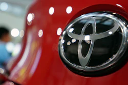 In this Aug. 2, 2019, file photo, people walk by the logo of Toyota at a show room in Tokyo.