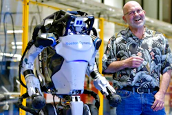Marc Raibert, founder and chair of Boston Dynamics, stands beside one of the company's Atlas robots at its facilities in Waltham, Mass., Jan. 13, 2021.
