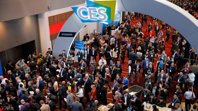 In this Jan. 7, 2020 file photo, crowds enter the convention center on the first day of the CES tech show, in Las Vegas. Every January, huge crowds descend on Las Vegas for the CES gadget show, an extravaganza of tech and glitz intended to set the tone for the coming year in consumer technology. CES kicks off this week, but thanks to the pandemic, it will be in a radical new format — a “virtual” show taking place only in cyberspace.