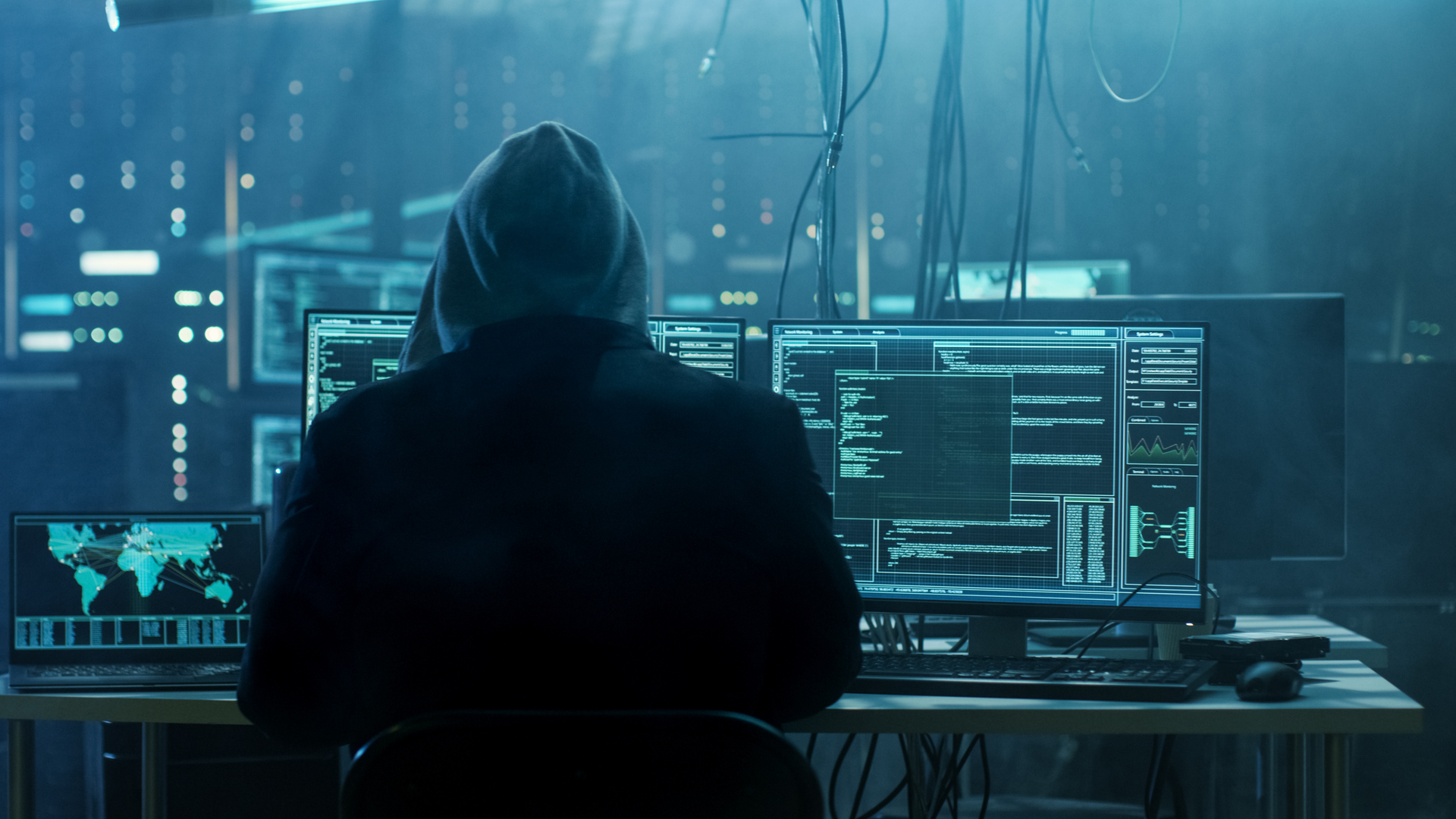 Dangerous Hooded Hacker Breaks Into Government Data Servers And Infects Their System With A Virus His Hideout Place Has Dark Atmosphere, Multiple Displays, Cables Everywhere 817486228 2313x1301 (1)