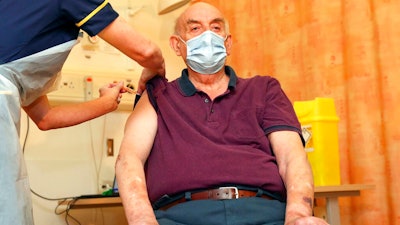 82-year-old Brian Pinker receives the Oxford University/AstraZeneca COVID-19 vaccine from nurse Sam Foster at the Churchill Hospital in Oxford, England, Monday, Jan. 4, 2021. Pinker, a retired maintenance manager received the first injection of the new vaccine developed by between Oxford University and drug giant AstraZeneca.