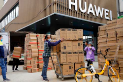 Workers move boxes of computers on a street in Wuhan, China, Jan. 16, 2021.