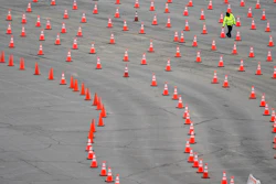 A worker arranges cones at a mostly-empty vaccination site at Dodger Stadium, Los Angeles, Feb. 11, 2021.