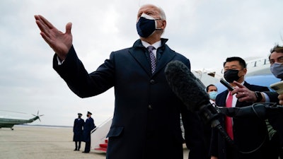 President Joe Biden speaks to member of the media after exiting Air Force One, Friday, Feb. 19, 2021, in Andrews Air Force Base, Md.