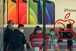People wearing face masks to help curb the spread of the coronavirus look at iPad devices at an Apple store at the capital city's popular shopping mall in Beijing on Wednesday, Feb. 24, 2021. China’s commerce minister appealed to Washington for “join efforts” revive trade but gave no indication Wednesday when tariff war talks might resume or whether Beijing might offer concessions.