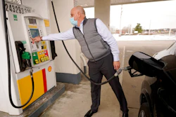 Jeremy Heskett, of Boston, prepares to pour gasoline at a Shell gas station, Thursday, Feb. 18, 2021, in Westwood, Mass. A deep freeze in the Gulf state region and beyond that killed dozens of people, left millions without power and jeopardized drinking water systems also forced as many as 11 refineries offline. The resulting capacity cuts could drive gas prices up by about 10 to 20 cents per gallon, said Patrick DeHaan, petroleum analyst at the travel app GasBuddy.