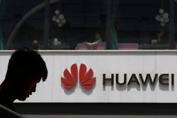 In this Thursday, May 16, 2019 file photo, a man is silhouetted near the Huawei logo in Beijing. Huawei took U.K. bank HSBC to court on Friday, Feb. 12, 2021 seeking documents the Chinese company says are key to its legal efforts to stop its chief financial officer from being extradited to the U.S. from Canada.