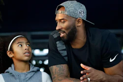 In this July 26, 2018, file photo, former Los Angeles Laker Kobe Bryant and his daughter Gianna watch the U.S. national championships swimming meet in Irvine, Calif. Federal safety officials are expected to vote Tuesday, Feb. 9, 2021, on what likely caused the helicopter carrying Kobe Bryant, his 13-year-old daughter and seven others to crash into a Southern California hillside last year, killing all aboard.