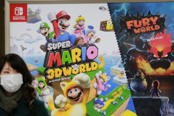 A woman walks by posters of Nintendo in Tokyo. The Japanese video game maker said profit surged to $3.6 billion.