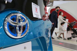 Visitors walk by a Toyota car displayed at its showroom in Tokyo.