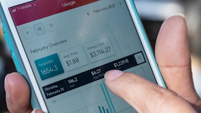 Ivet Cantu, 45, points to her electricity bill from Griddy Energy on an app showing her energy cost of $3,114.27, during recent severe cold weather outside of her home in Dallas.