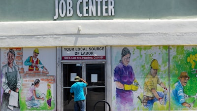 In this file photo, a person looks inside the closed doors of the Pasadena Community Job Center.