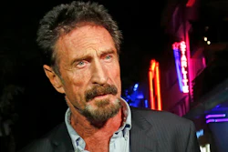 In this Dec. 12, 2012 file photo, anti-virus software founder John McAfee answers questions to reporters as he walks on Ocean Drive, in the South Beach area of Miami Beach, Fla. McAfee was indicted on fraud and money laundering conspiracy charges alleging that he and cohorts made over $13 million by fooling investors zealous over the emerging cryptocurrency market, authorities said Friday, March 5, 2021.