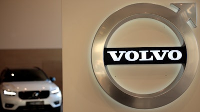 This file photo a Volvo car is parked behind the Volvo logo in the lobby of the company's corporate headquarters, in Brussels.