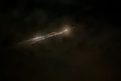Image taken from video showing debris from a SpaceX rocket behind clouds over Vancouver, Wash., March 25, 2021.