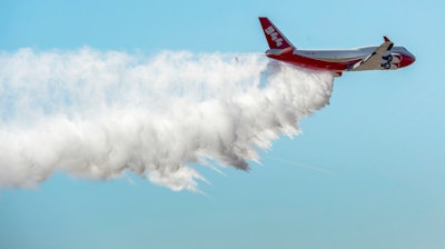 A Boeing 747-400 Global SuperTanker drops half of its 19,400-gallon capacity during a ceremony, Colorado Springs, Colo., May 5, 2016.
