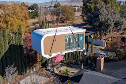 This photo provided by Mighty Buildings shows a 3D-printed housing module being delivered. Most of the modules built by Mighty Buildings are assembled in the factory, transported by truck to the owner’s property, then put into place using a crane.