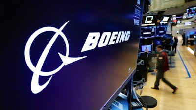 In this March 11, 2019 file photo, the Boeing logo appears above a trading post on the floor of the New York Stock Exchange before the opening bell. Boeing is suing a subcontractor it hired to work on new Air Force One planes that will carry the president of the United States. Boeing says a subcontractor on in Fort Worth, Texas, missed deadlines for work on the planes.