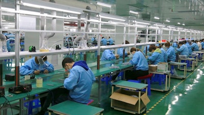 Workers put together electronic gears at a factory in Zhangye in northwestern China's Gansu Province on April 17, 2021. Two surveys show Chinese manufacturing expanded in April but growth appeared to be slowing after a rebound from the coronavirus pandemic.