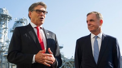 In this Thursday, July 26, 2018 file photo, Secretary of Energy Rick Perry, left, with the main cyrogenic heating exchange behind him, and Thomas Farrell, II, chairman, president and CEO, Dominion Energy, speak with reporters at Dominion Energy's Cove Point LNG liquefaction Project facility in Lusby, Md., Tom Farrell, who led Dominion Energy for more than a decade, has died Friday, April 2, 2021 one day after he stepped down from his post. He was 66.