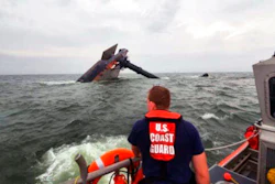 In this photo provided by the U.S. Coast Guard, A Coast Guard Station Grand Isle 45-foot Response Boat-medium boat crew member searches for survivors near the capsized SeaCor Power. The Seacor Power, an oil industry vessel, flipped over Tuesday, April 13, 2021 in a microburst of dangerous wind and high seas.