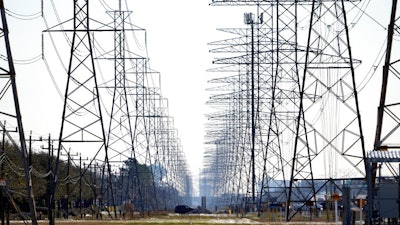 This Tuesday, Feb. 16, 2021 file photo shows power lines in Houston. The Biden administration is taking steps to protect the country’s electric system from cyberattacks through a new 100-day initiative combining federal government agencies and private industry. The initiative was announced Tuesday by the Energy Department.