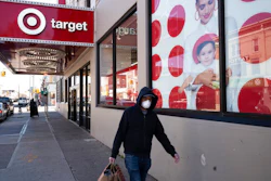 In this April 6, 2020 file photo, a customer wearing a mask carries his purchases as he leaves a Target store during the coronavirus pandemic, in the Brooklyn borough of New York. Target says it will spend a a total of more than $2 billion at Black-owned businesses by 2025 as part of its effort to advance racial equity. As part of its program, the Minneapolis-based discounter will add products from more than 500 Black-owned businesses across all types of merchandising areas.