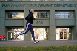 In his Dec. 18, 2020, file photo a runner passes the office of the California Employment Development Department in Sacramento, Calif. California lawmakers on Thursday, April 8, 2021, advanced what they called commonsense legislation requiring two state agencies to share information aimed at helping stop billions of dollars in pandemic-related unemployment fraud.
